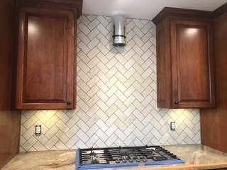 Completed herringbone kitchen tile backsplash