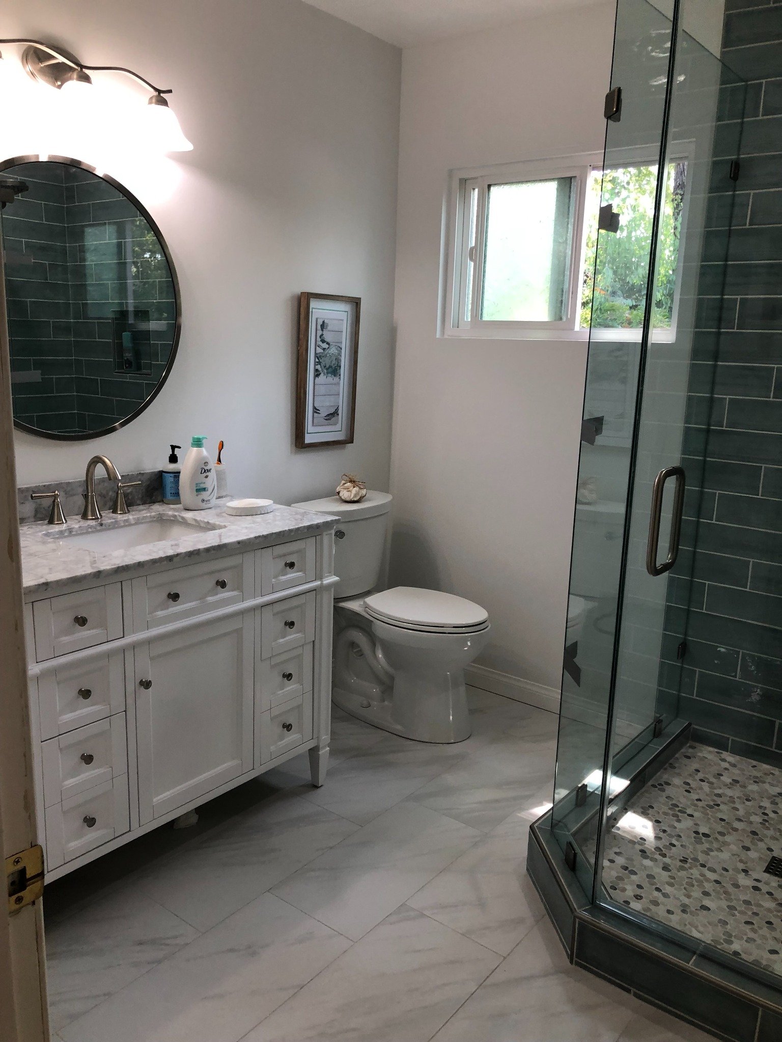 Completed bathroom with blue-gray tiled glass shower and finished floor