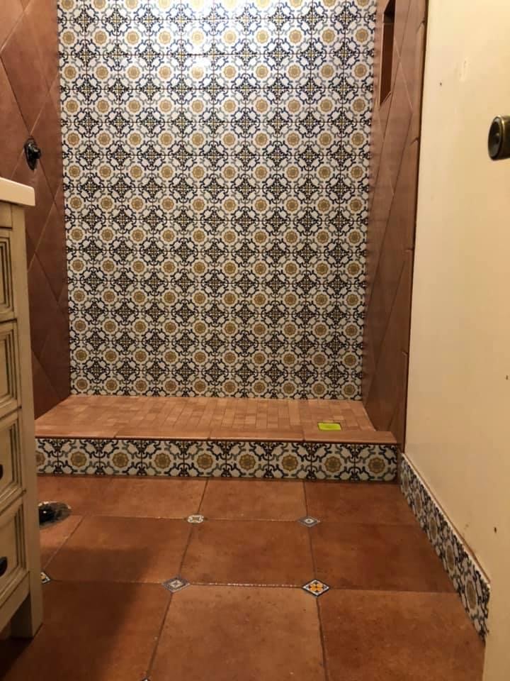 Completed decorative custom shower with patterned feature wall and warm-toned tile