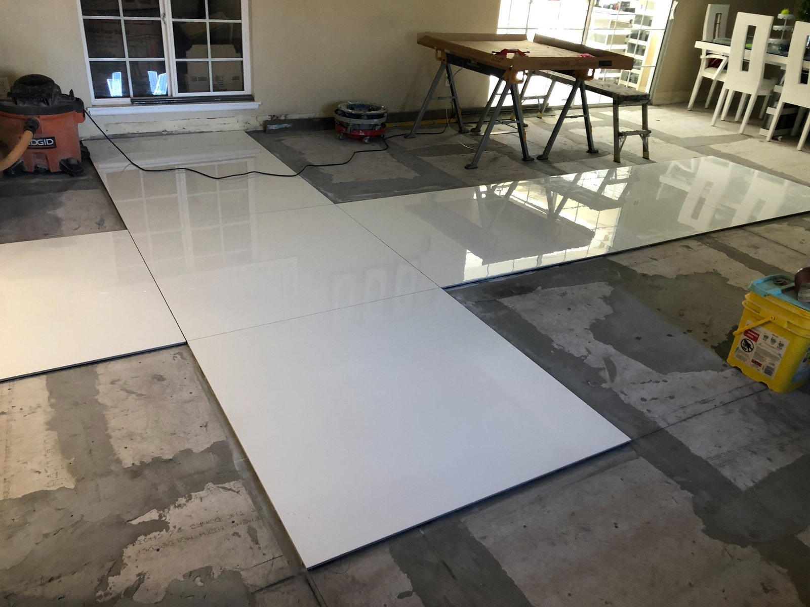Large-format white tile panels being installed across interior floor